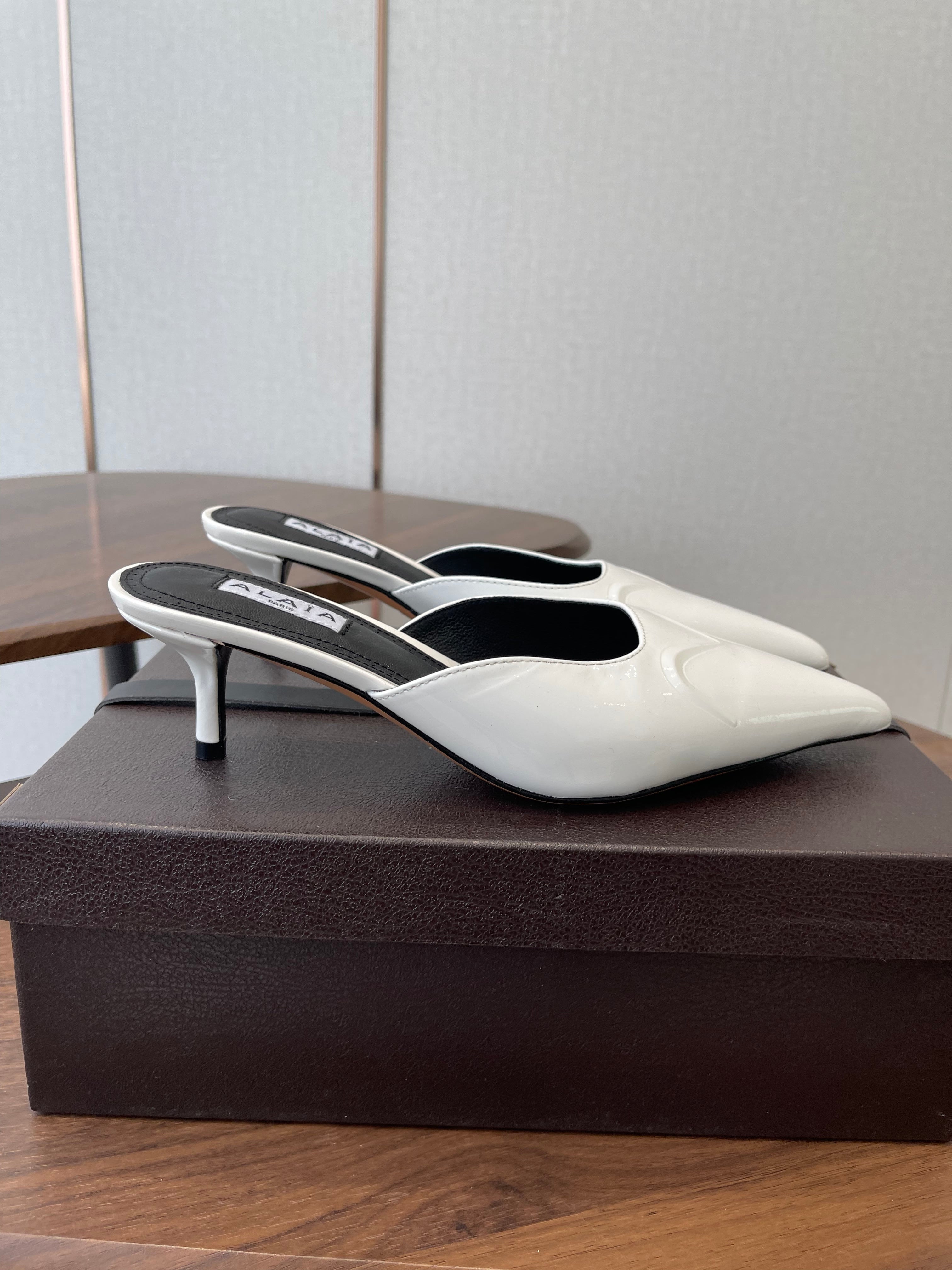 ALAIA 26S HEELED MULES 50 MM IN WHITE GLOSSY CALFSKIN