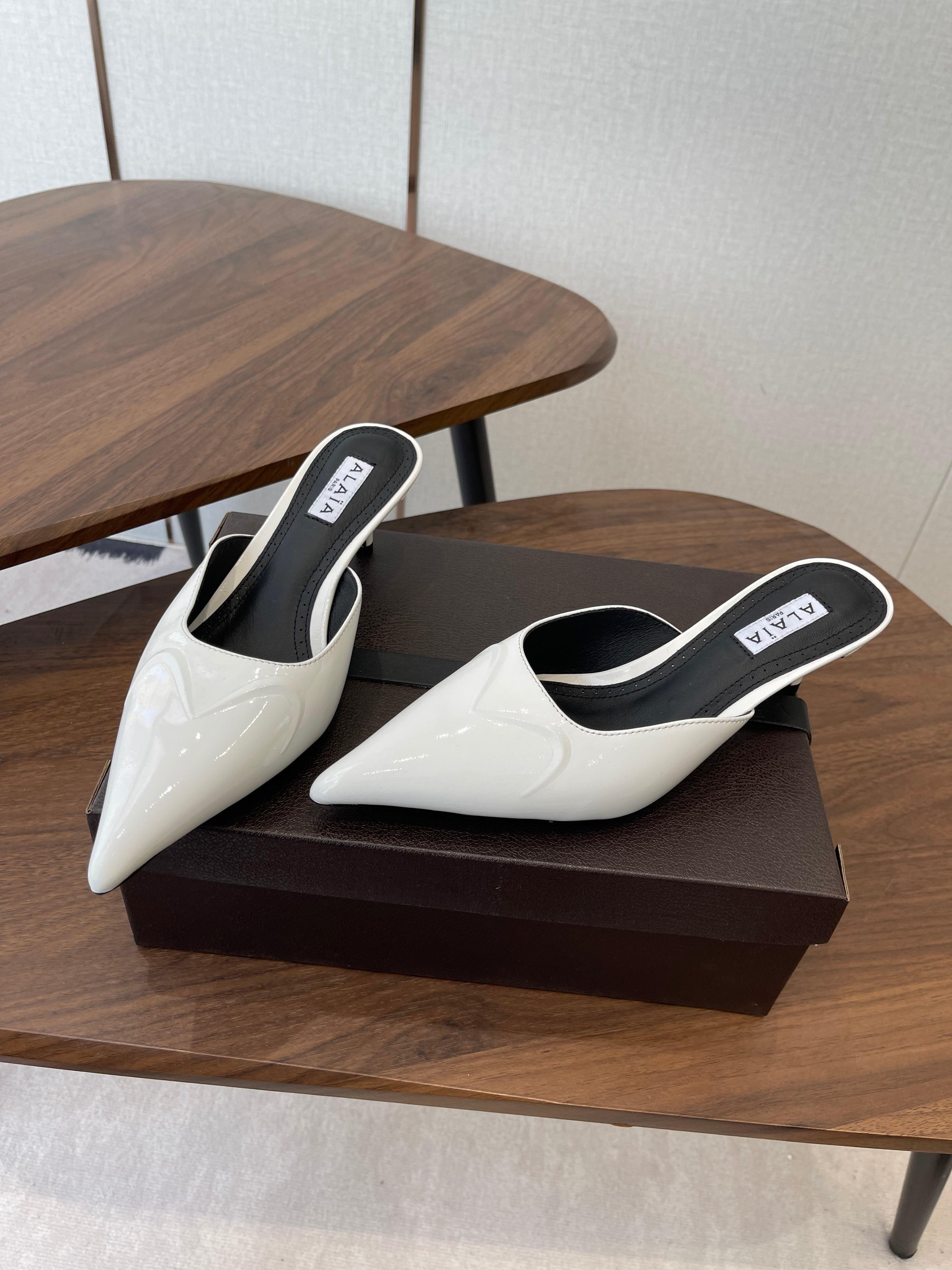 ALAIA 26S HEELED MULES 50 MM IN WHITE GLOSSY CALFSKIN