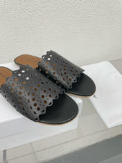 ALAIA VIENNE FLAT MULES IN BLACK LAMBSKIN